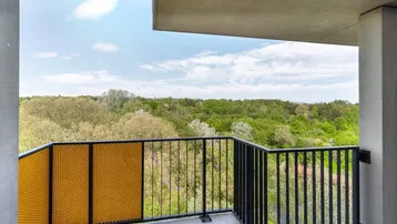 Geräumiger Balkon mit moderner Brüstung und weitem Blick ins Grüne.