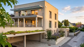 Modernes Mehrfamilienhaus mit mehreren Balkonen, Carport und gepflegter Außenanlage bei Sonnenuntergang.