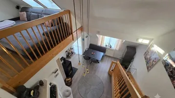 Großzügiger Wohn-Essbereich von oben gesehen mit Kamin, Galerie und Dachfenstern.