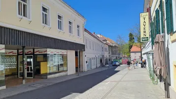 Eine belebte Straße mit Geschäften und Restaurants, die zum Flanieren und Verweilen einlädt.