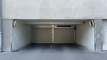Eingang zur Tiefgarage mit zwei Rolltoren und einer Höhenbegrenzung von 2 Metern.