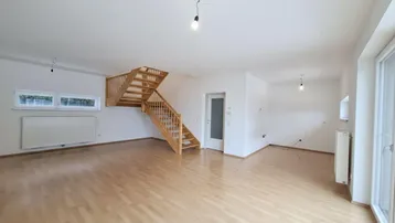 Helles, geräumiges Wohnzimmer mit Holztreppe und Parkettboden, bereit zur individuellen Gestaltung.