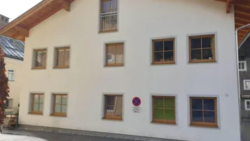 Rückansicht des Gebäudes mit Holzbalken, Satteldach und einem französischen Balkon im Obergeschoss.
