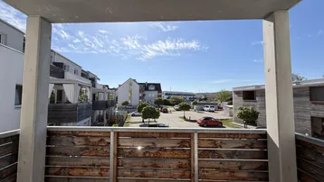 Panoramablick vom Balkon über die Nachbarschaft mit weiteren Wohngebäuden und Parkplätzen.
