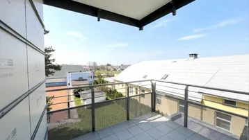 Heller Balkon mit Fliesenboden und Metallgeländer, bietet einen weiten Blick über die Umgebung.