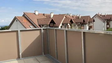 Balkon mit Fliesenboden und einem weiten Blick über die Dächer der Nachbarschaft.
