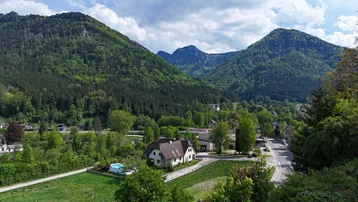 Panoramablick auf ein Wohnhaus in einer grünen Berglandschaft mit einem kleinen Pool.
