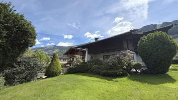 Außenansicht des Hauses mit großem Garten und Bergblick.