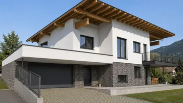 Modernes Einfamilienhaus mit integrierter Garage, Holzdachkonstruktion und Bergblick in sonniger Lage.