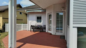 Geräumige Terrasse mit Ziegelboden und Gartenmöbeln, ideal für entspannte Stunden im Freien.
