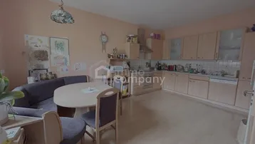 Geräumige Wohnküche mit Holzeinbauten, Essbereich und ausreichend Platz für die Familie.