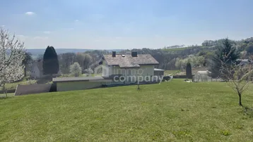 Weitläufige Außenansicht des Hauses mit großem Rasen und Panoramablick auf die Landschaft.