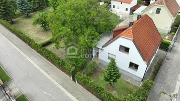 Drohnenaufnahme eines Einfamilienhauses mit Garten und umliegender Nachbarschaft.