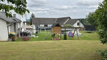 Großer Gartenbereich mit Spielplatz, Trampolin und einer gemütlichen Sitzecke im Freien.
