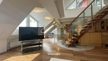 Geräumiger Wohnbereich im Dachgeschoss mit Holzboden, großen Fenstern und offener Treppe zum oberen Stockwerk.