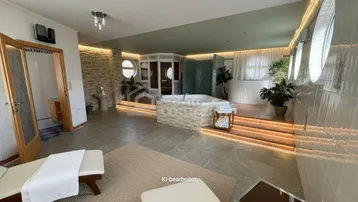 Geräumiger Wellnessbereich mit Whirlpool, Sauna, Liegen und indirekter Beleuchtung.