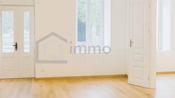Heller Raum mit hohen Decken, großen Fenstern und Holzboden, ideal für Wohn- oder Essbereich.