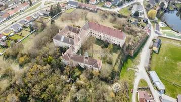 Nähere Luftansicht des historischen Anwesens mit Innenhof und angrenzendem See oder Teich.