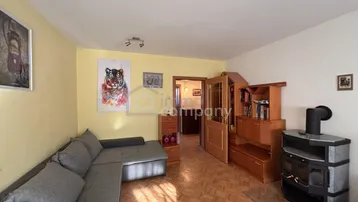 Gemütliches Wohnzimmer mit Parkettboden, Ecksofa und einem Kaminofen für wohlige Wärme.