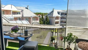 Möblierter Balkon mit Kunstrasen, Markise und weitem Blick über die Dächer der Nachbarschaft.
