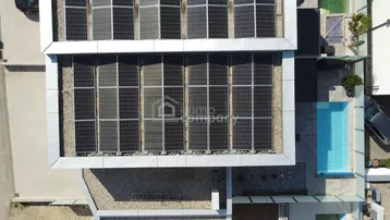 Luftaufnahme des Daches mit Photovoltaikanlage und angrenzendem Poolbereich.