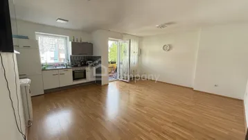 Heller offener Wohn- und Essbereich mit Parkettboden und Zugang zum Balkon.