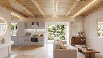 Heller offener Wohnbereich mit integrierter Küche, Holzbalkendecke und Zugang zum Garten.