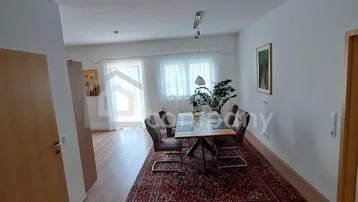 Heller Essbereich mit Holzboden, Teppich und Zugang zu einem Außenbereich.