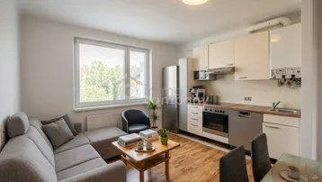 Offener Wohnbereich mit integrierter Küche, Sofa und Esstisch, ideal für geselliges Beisammensein.