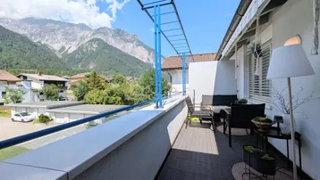 Großer Balkon mit Sitzgelegenheiten und einem atemberaubenden Blick auf die Berge.