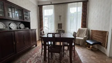 Traditioneller Essbereich mit dunklem Holzbuffet, gemusterter Tapete und Teppichboden, der eine gemütliche Atmosphäre schafft.