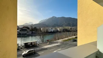 Ausblick vom Balkon auf den Fluss, die Straße und die majestätischen Berge im Hintergrund.