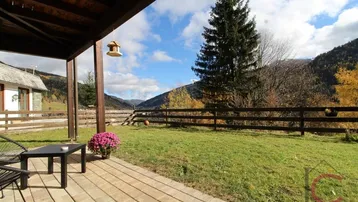 Überdachte Terrasse mit Sitzgelegenheiten und weitem Blick auf die umliegende Berglandschaft.