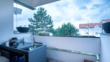 Gemütlicher Balkon mit Sitzgelegenheiten und Blick ins Grüne, ideal zum Entspannen.