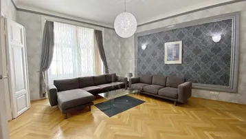 Geräumiges Wohnzimmer mit Fischgrätparkett, Stuckdecke und eleganter Tapete.