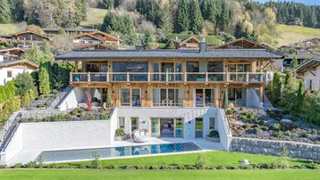 Luxuriöses Anwesen mit modernem Design, großem Garten und Infinity-Pool in alpiner Umgebung.