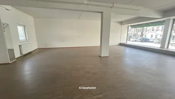 Geräumiger, leerer Gewerberaum mit großen Schaufenstern und Blick auf die Straße.