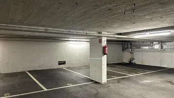 Geräumige Tiefgarage mit markierten Stellplätzen und sichtbarer Betonkonstruktion.