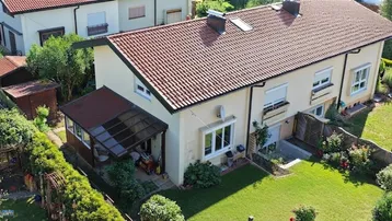 Luftaufnahme eines Einfamilienhauses mit Garten, überdachter Terrasse und gepflegter Rasenfläche.
