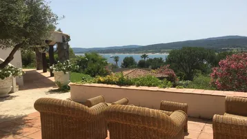 Geräumige Terrasse mit Korbmöbeln und weitem Blick auf das Meer und die umliegende Landschaft.
