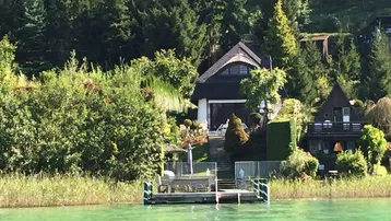 Idyllisches Anwesen am Seeufer mit privatem Bootssteg und umgebender Natur.