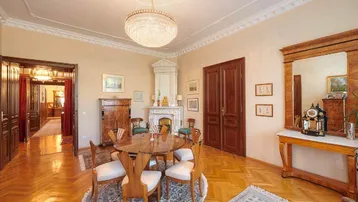 Elegantes Esszimmer mit Fischgrätparkett, Stuckdecke und einem prunkvollen Kamin.