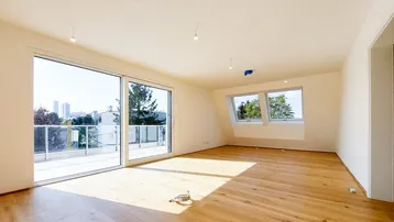 Heller Raum mit Holzboden, großen Schiebetüren zum Balkon und Dachfenstern, bietet Stadtblick.