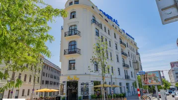 Elegantes Eckgebäude mit klassischer Architektur und Balkonen in urbaner Umgebung.