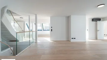 Heller, offener Wohnbereich mit modernem Parkettboden und eleganter Treppe mit Glasgeländer.