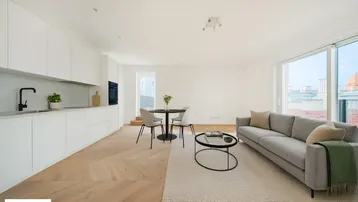 Heller, offener Wohn-Essbereich mit moderner Einbauküche, Parkettboden und Zugang zur Terrasse.