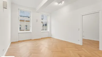Helles Zimmer mit Fischgrätparkett und hohen Fenstern, frisch renoviert und bezugsfertig.