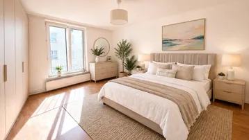 Helles Schlafzimmer mit Holzboden, großem Bett, Einbauschränken und natürlichem Lichteinfall durch das Fenster.