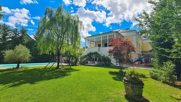 Großzügiger Gartenbereich mit gepflegtem Rasen, altem Baumbestand und einem erfrischenden Swimmingpool.