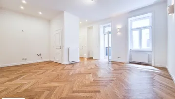 Helles Zimmer mit Fischgrätparkett und Zugang zu einem französischen Balkon, bereit zum Einzug.